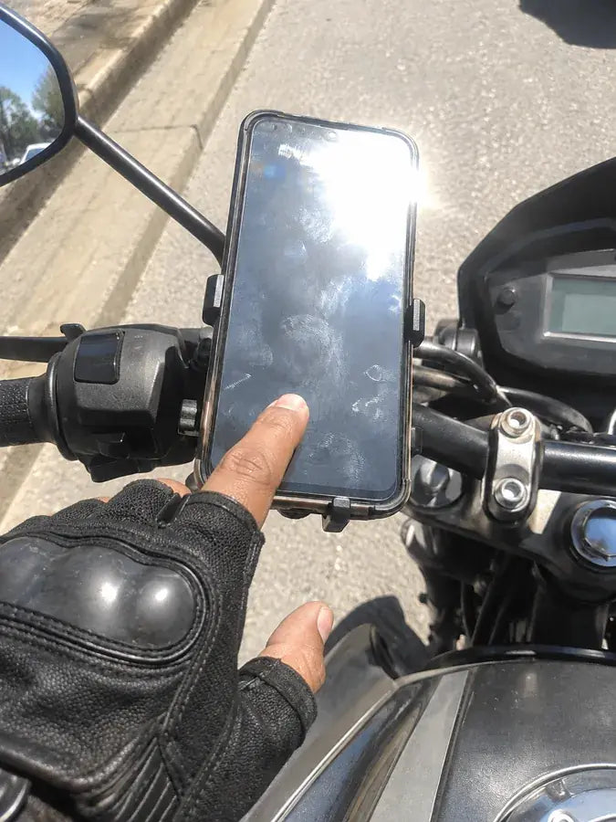 Celular en el manubrio con la pantalla ilegible por el sol